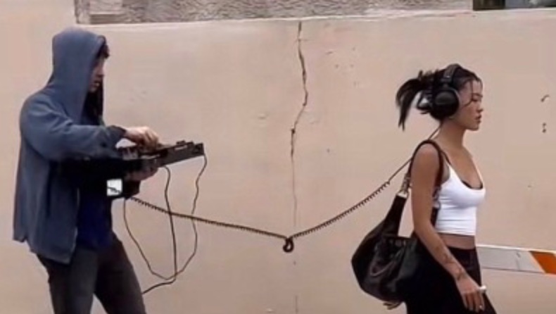 Person holding microphone following woman with headphones